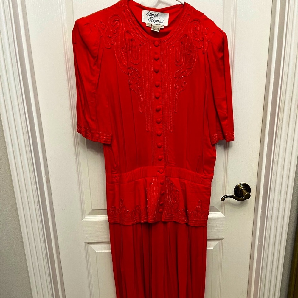 Ankle length embroidered dress in peach. Buttons from neck to the waist. Size 14